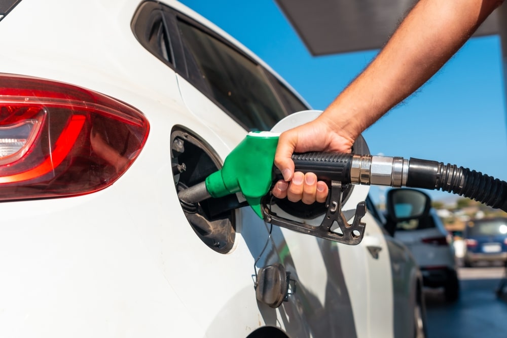 person filling up their car with petrol to denote petrol prices in the UK dropping