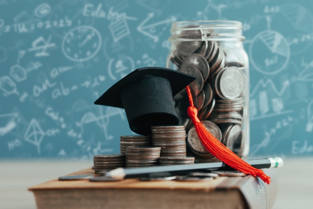 A graduation hat on a stack of coins to denote student loan overpayments