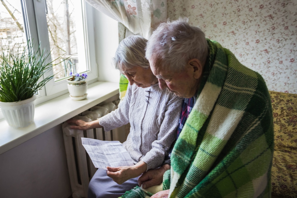 Two pensioners with blankets over them to denote the winter fuel payment impact on pensioners