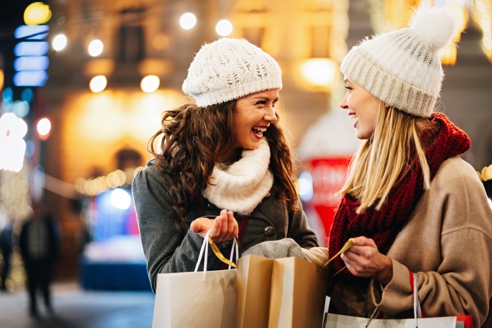 Two women christmas shopping as christmas spending to increase on last year