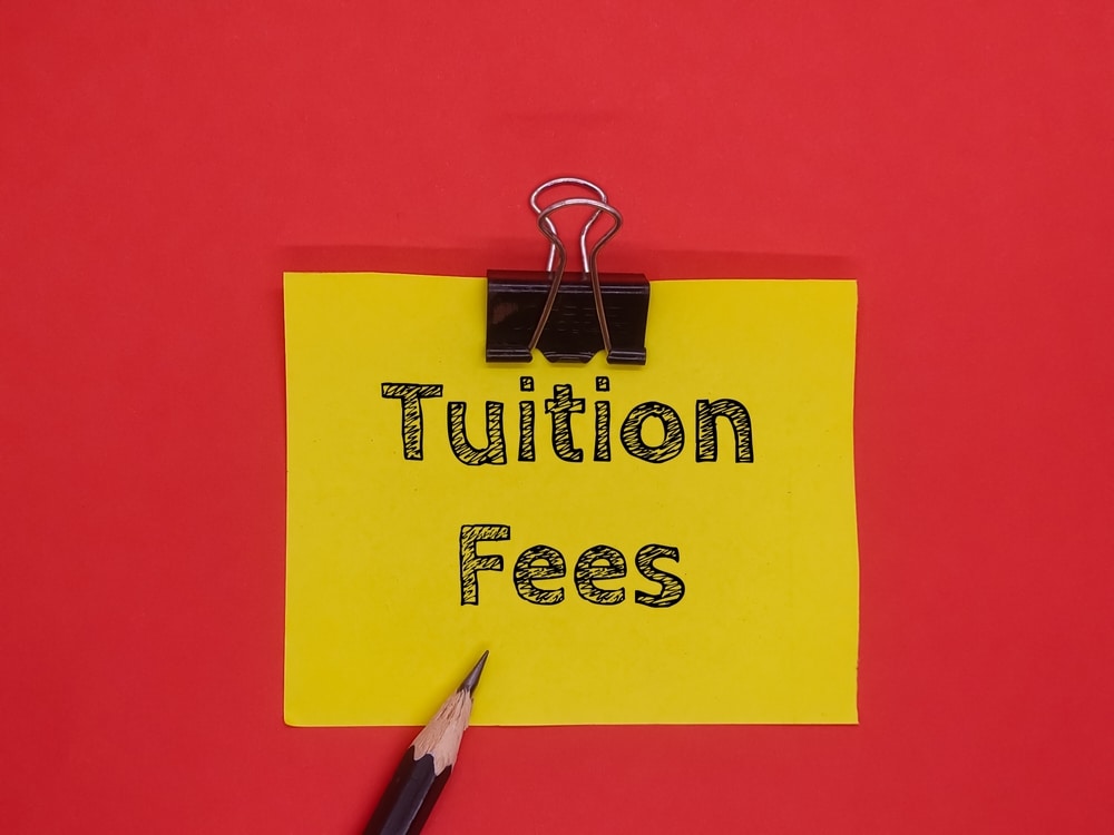 An image of a post it note with tuition fee to denote that tuition fees rise