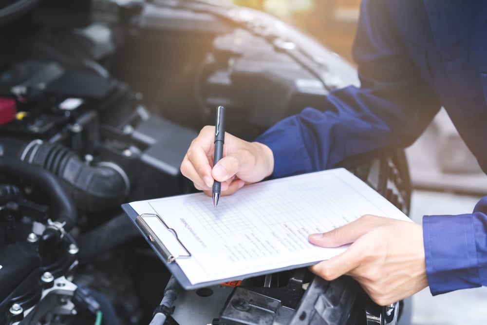 A mechanic with a clipboard as part of tips on how to pass your MOT