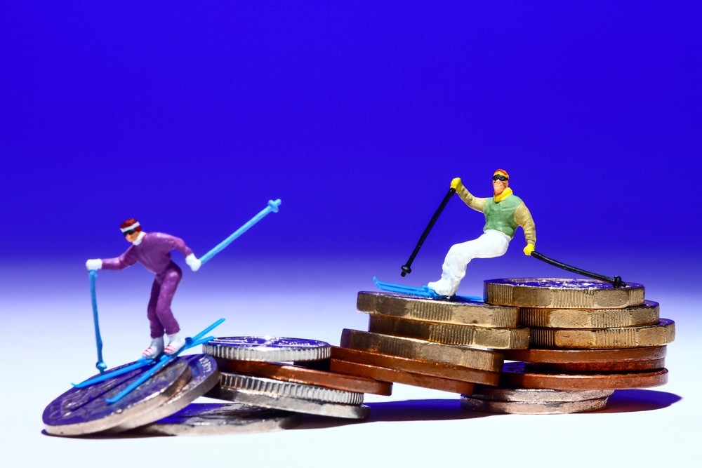 two miniature people skiing down coins to denote the best best holiday accounts