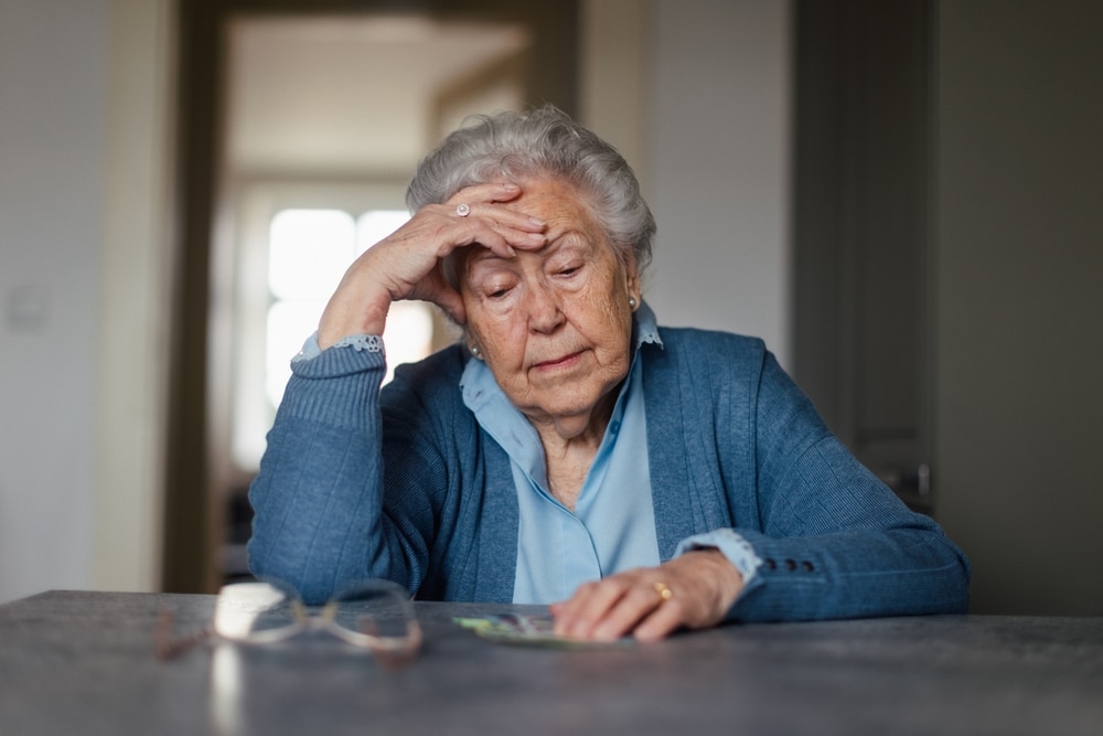 An older woman counting her money as pensioner homeowners miss out on govt support