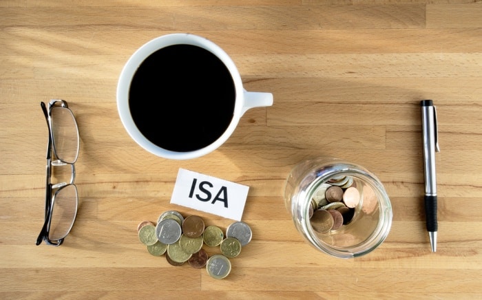 a drink next to a pile of coins and the word 'isa' to denote investment funds for your ISA